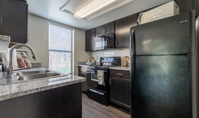 Kitchen with brown cabinets and black appliances
